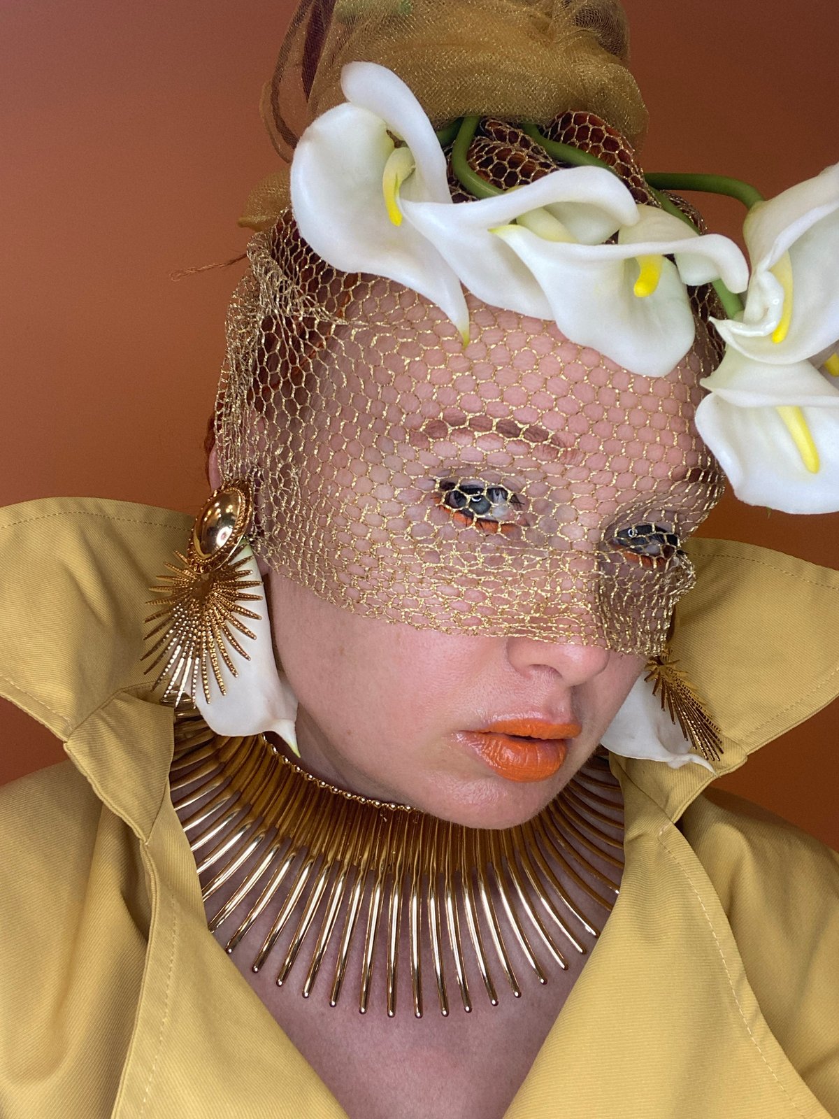 Avant-garde fashion shoot featuring gold veils and calla lilies