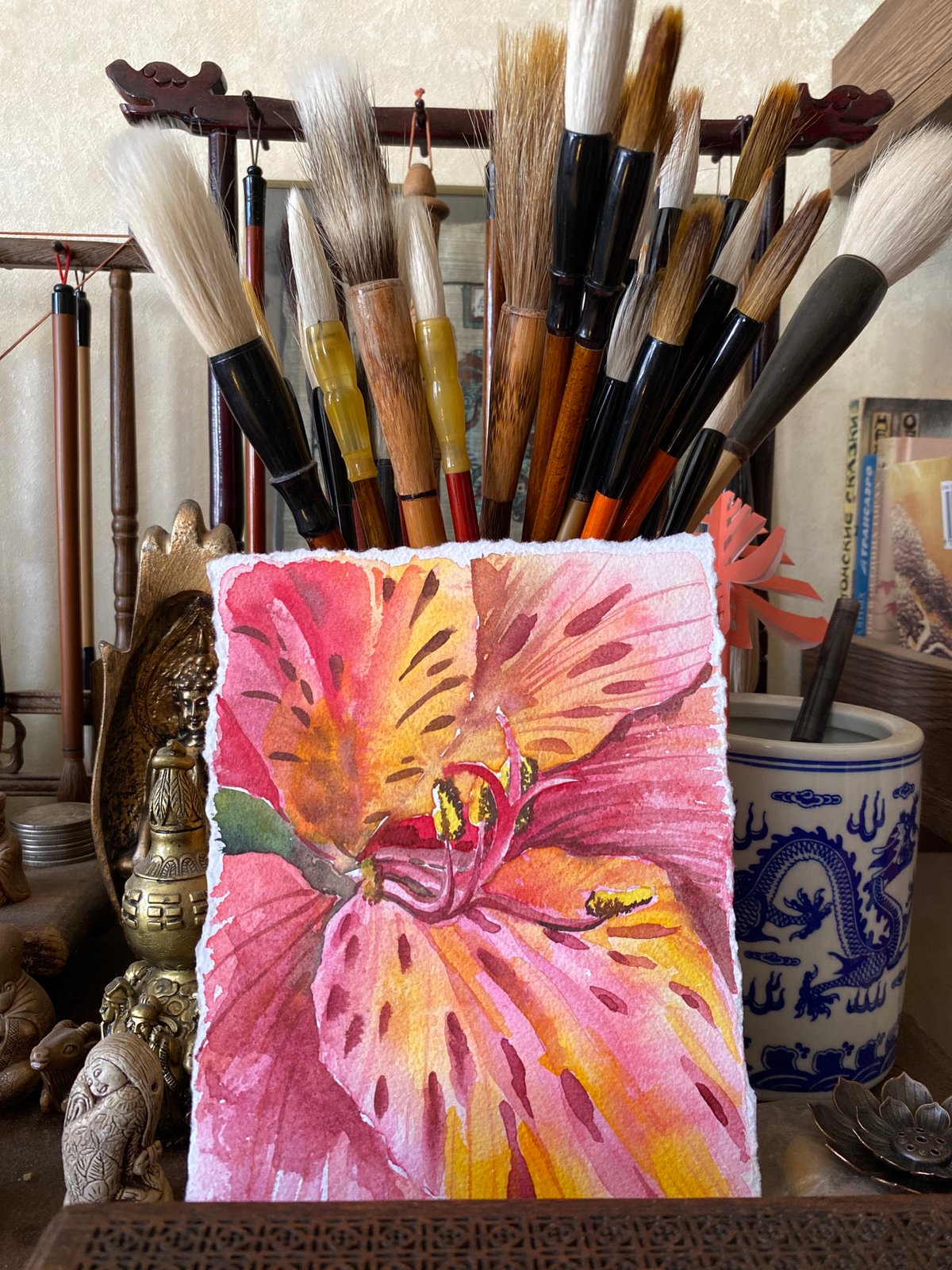 Artist workspace documented in Izhevsk showing brushes, painting, Santa hat