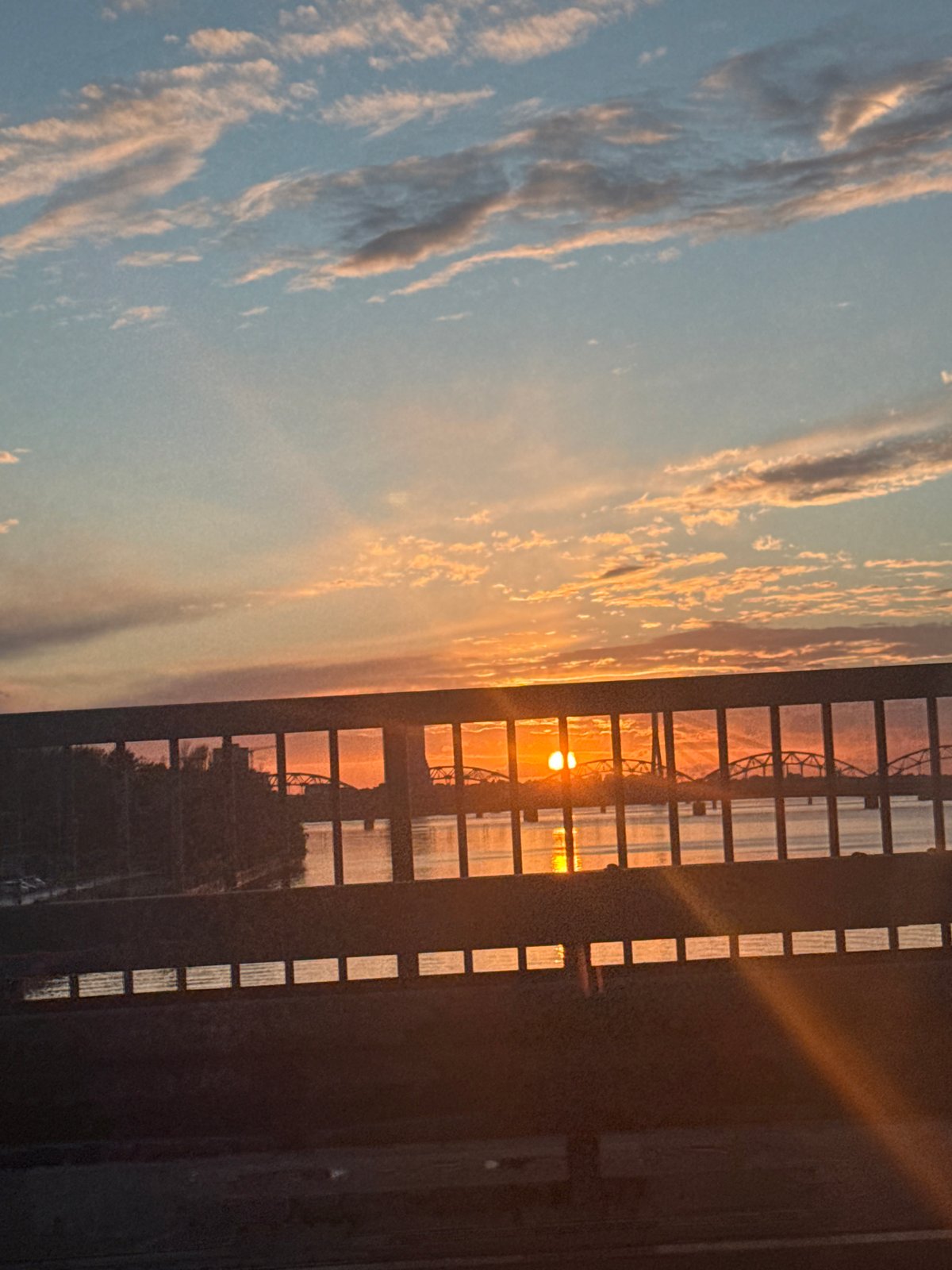 Gridded window frames a vivid sunset over Riga