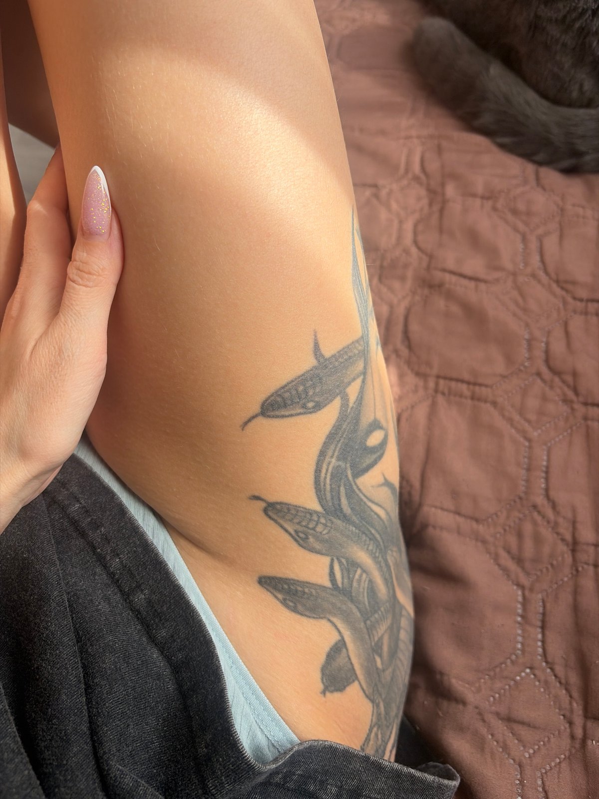 Morning relaxation scene with tattooed person and cat in Saint Petersburg