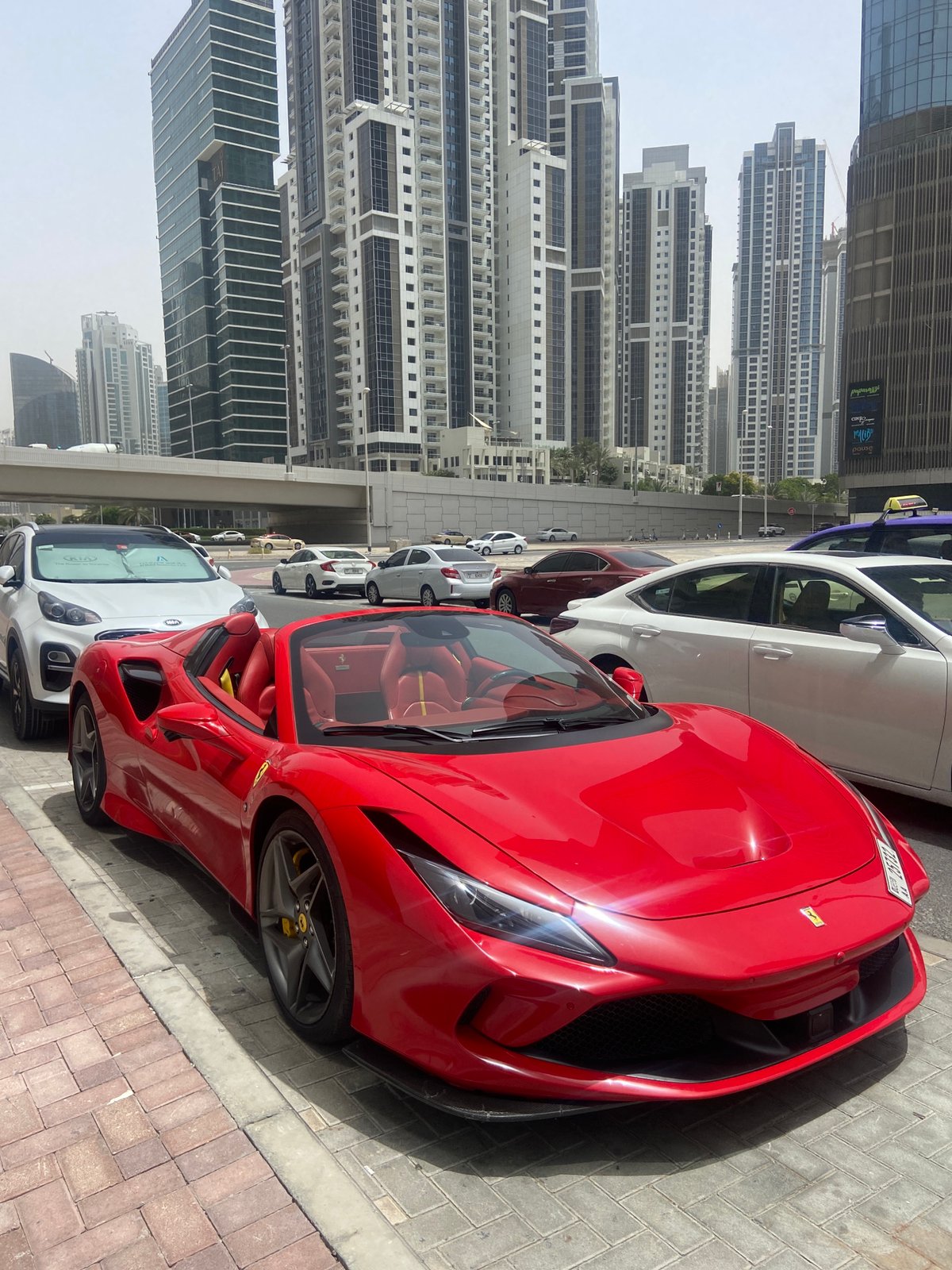 Red Ferrari spotted among parked cars in Dubai Business Bay