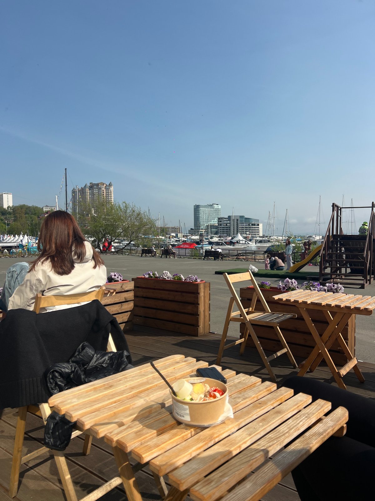 Woman takes morning selfies at Vladivostok marina with takeout