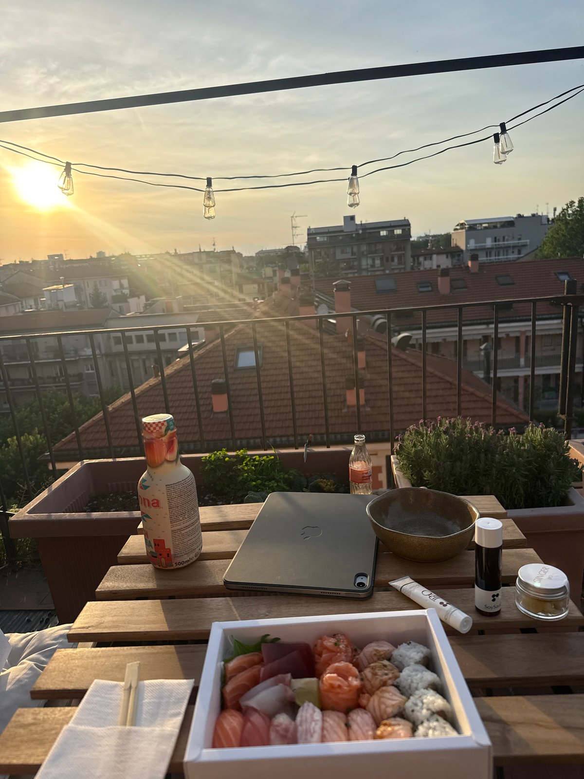 Sunset dinner setting captured on Milan balcony overlooking cityscape