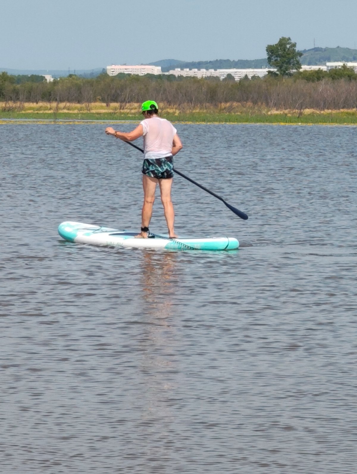 Paddleboarding on calm water, standing and kneeling