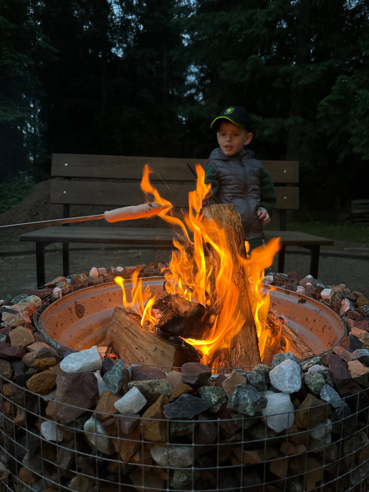 Boy tends fire pit during outdoor cooking in Russia