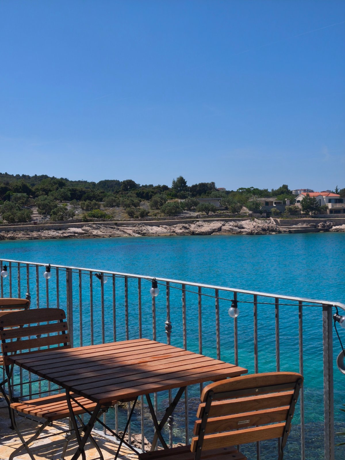 Coastal cove with turquoise waters and hillside dining captured