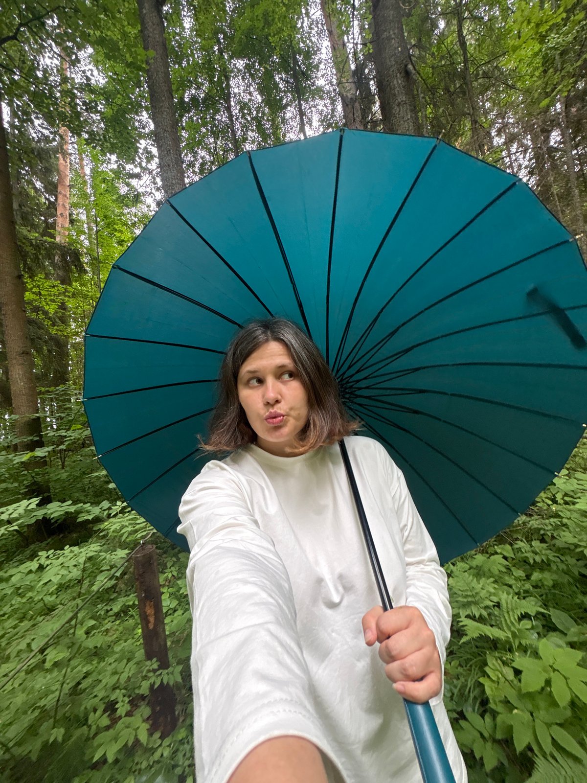 Rainy forest walk in Kostovaty, teal umbrella in tow