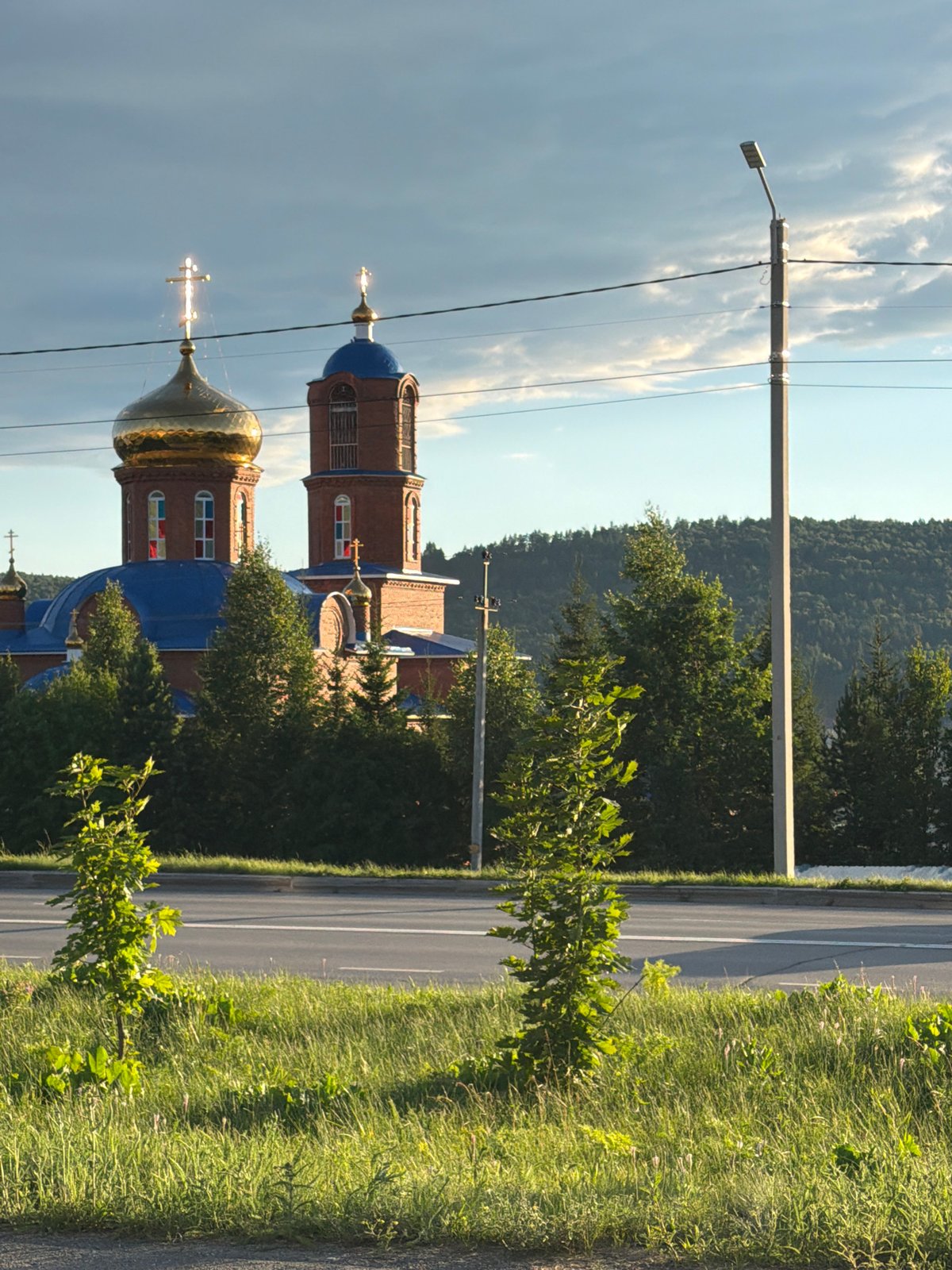 Rural roads and church domes under a golden sunset sky
