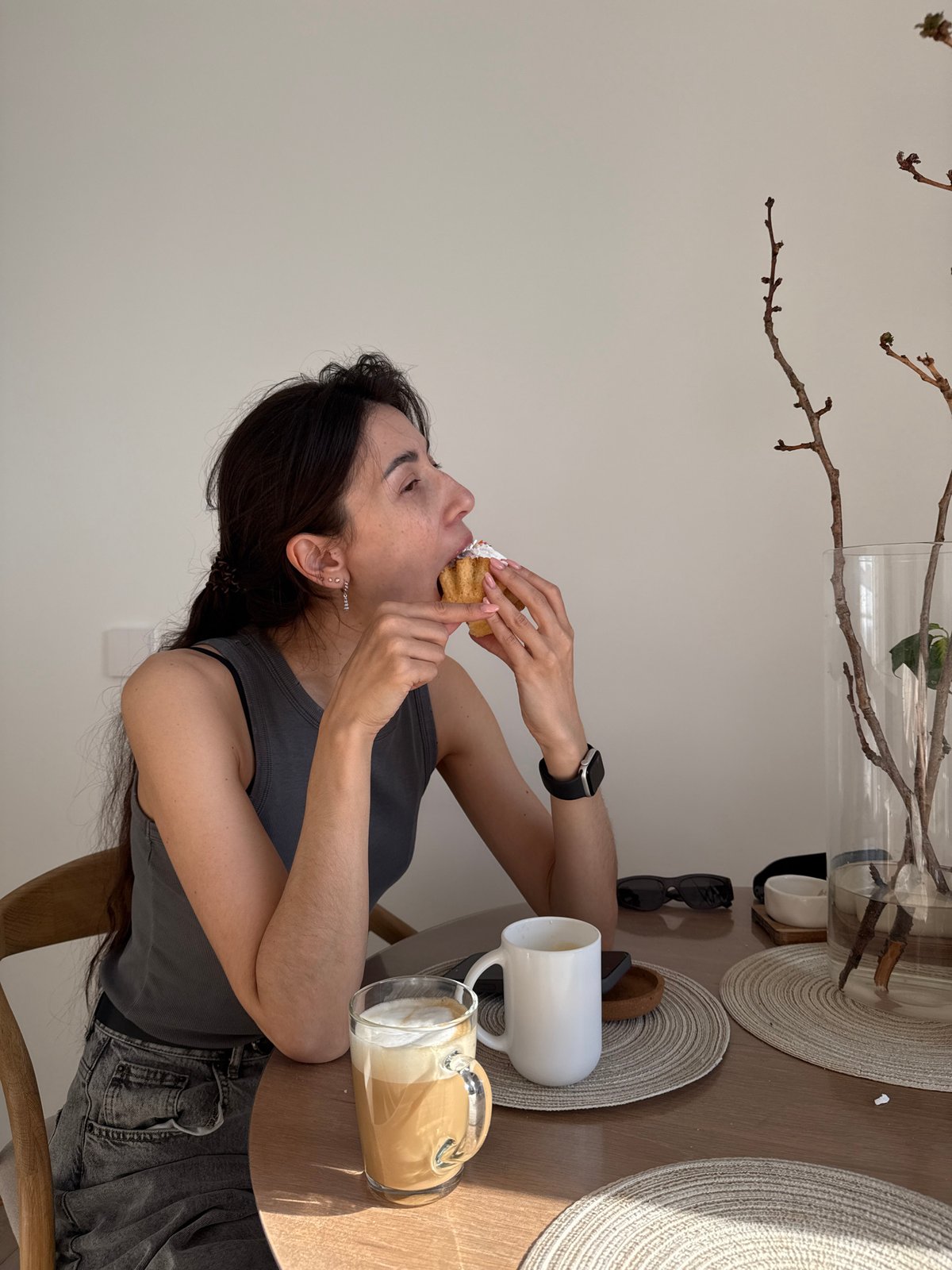 Woman enjoys cupcake at table in Perm, Russia