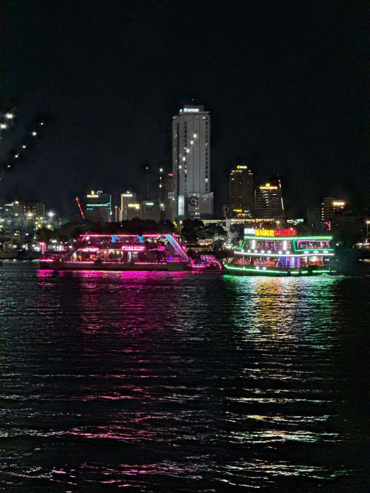 Illuminated tour boats cruise Han River in nighttime Đà Nẵng