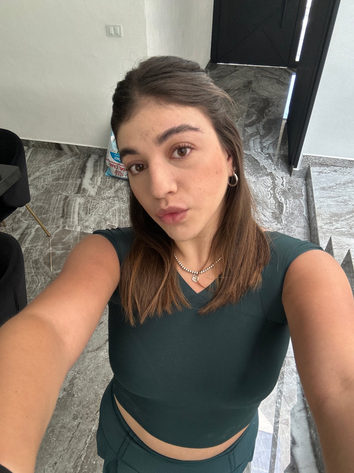 Woman takes selfies in green workout clothes in Puebla