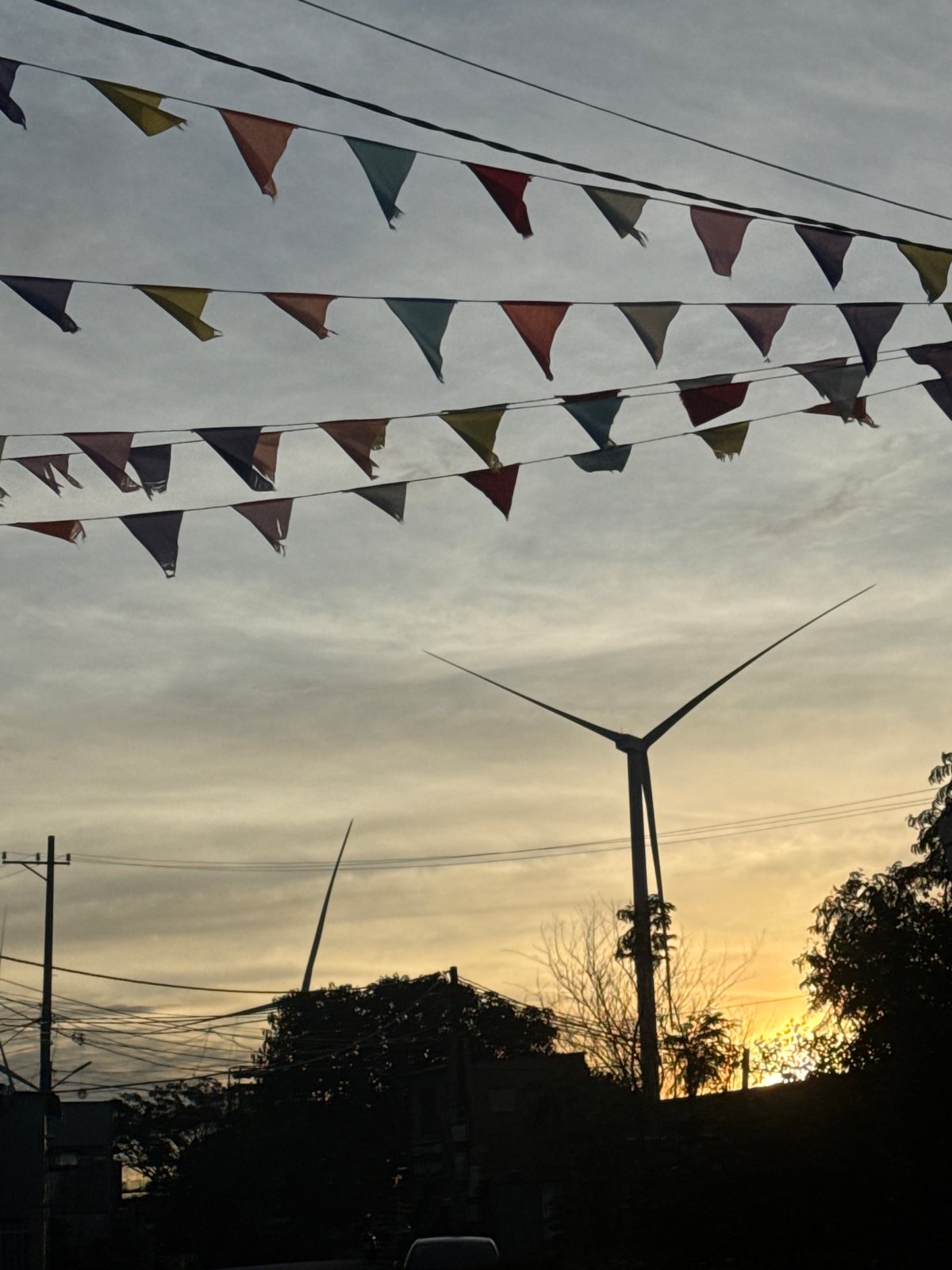 Wind turbine and pennant strings under cloudy skies in Trường Thọ