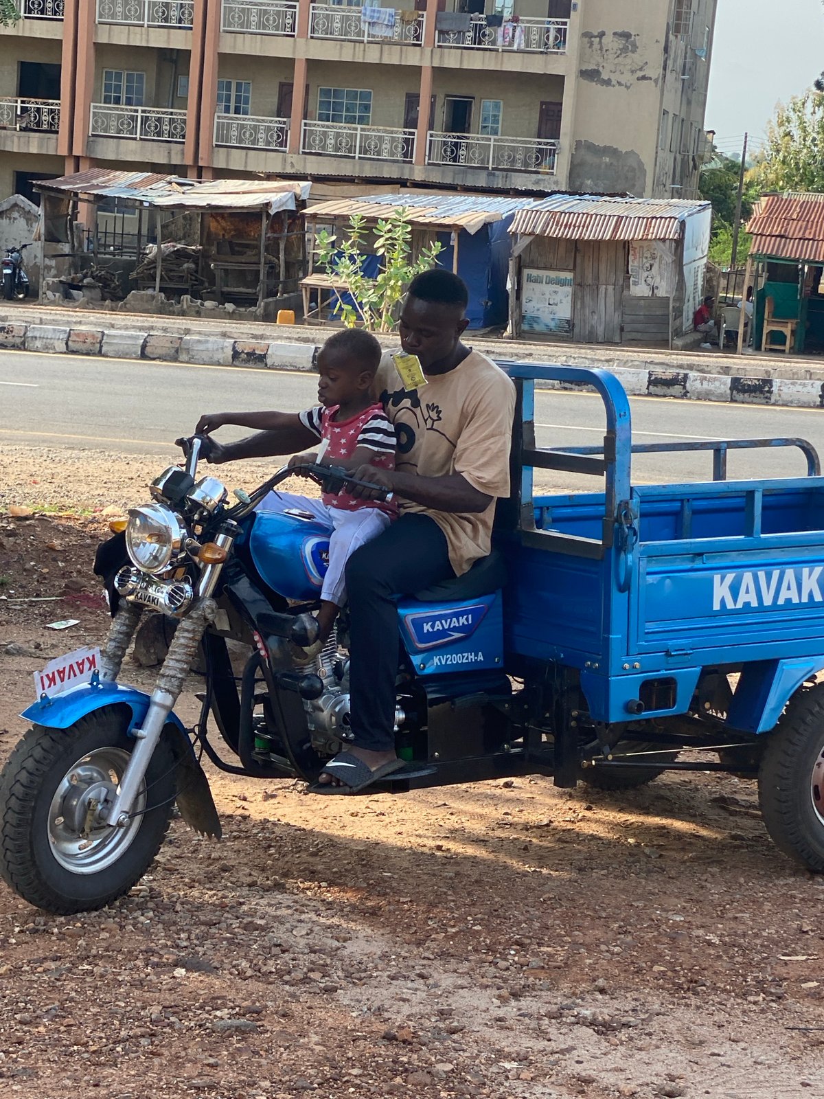 Man, child share motorcycle ride in Nigerian town