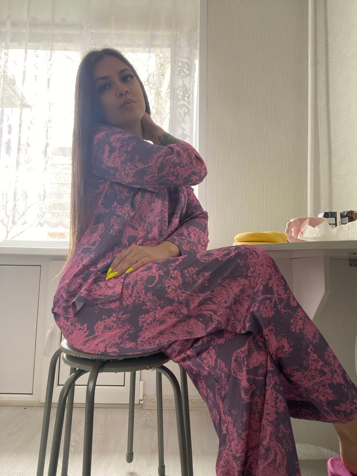 Woman in purple pajamas sits indoors in Chaikovsky, Russia