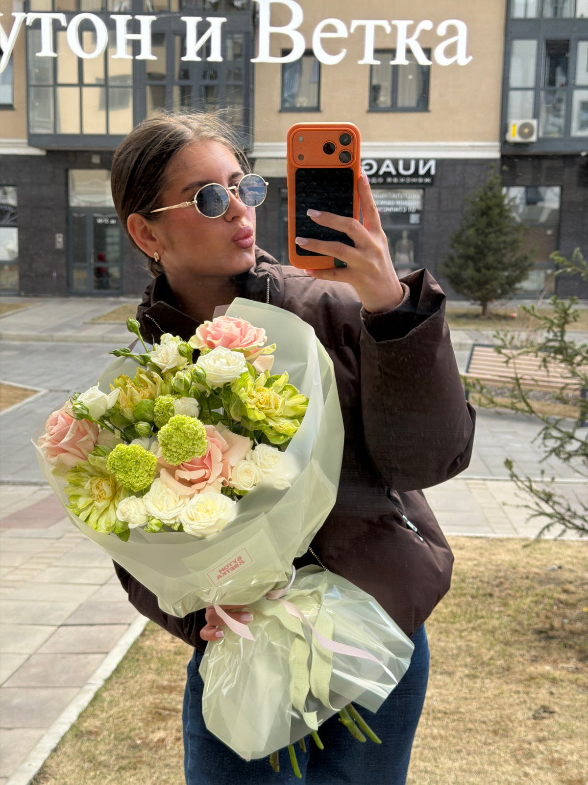 Woman takes selfie with flowers at Krasnoyarsk market