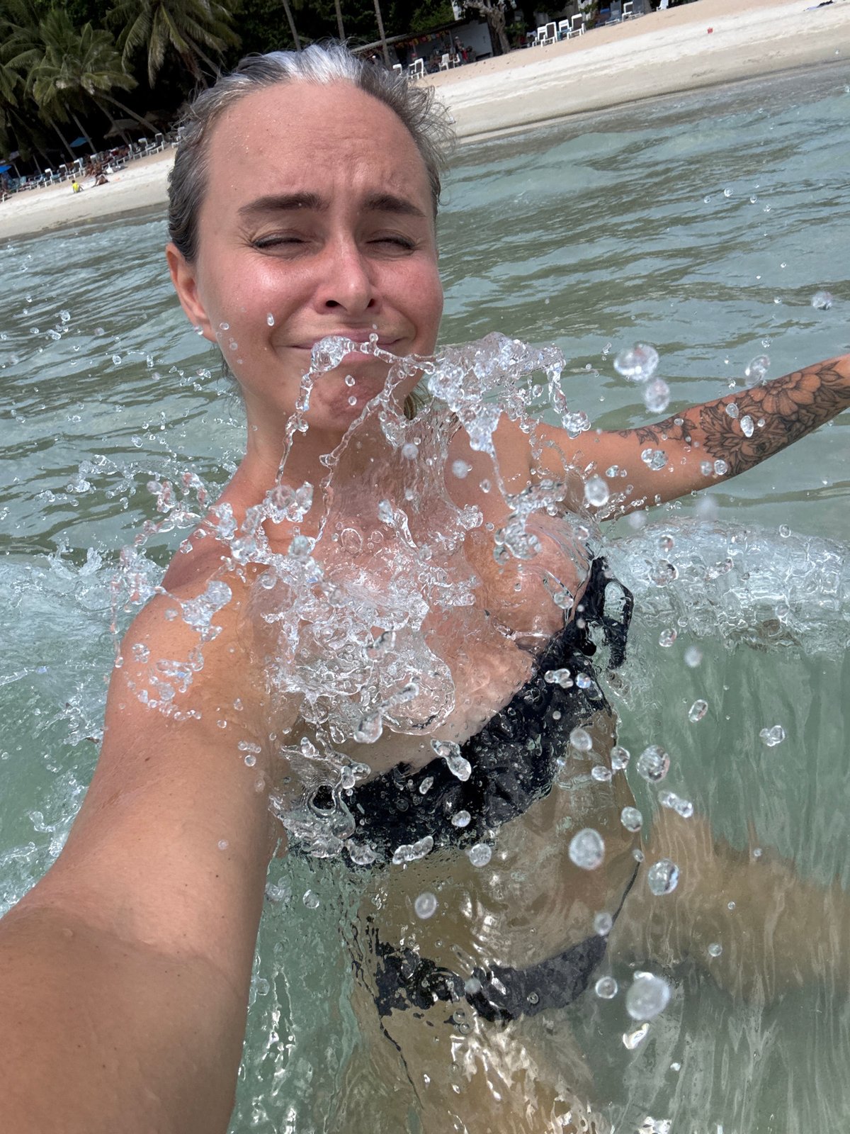 A lively Ko Samui beach morning with swimmers, selfies, and rentals