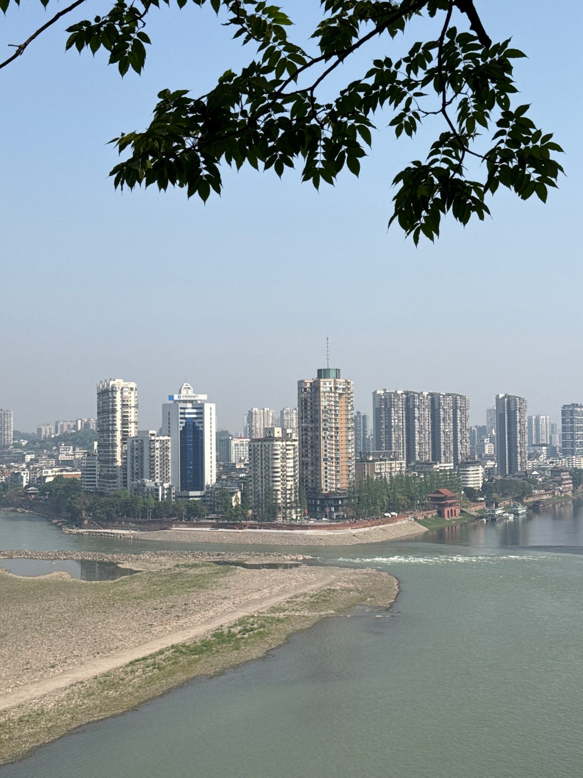 Panoramic riverside cityscape observed from elevated viewpoint in Shizhong