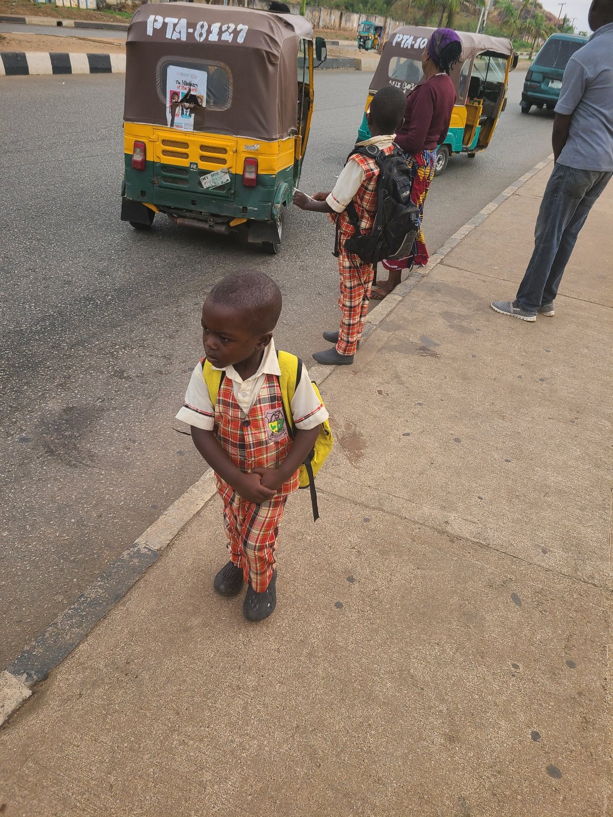 Morning street life in Jos, Nigeria features students and commuters