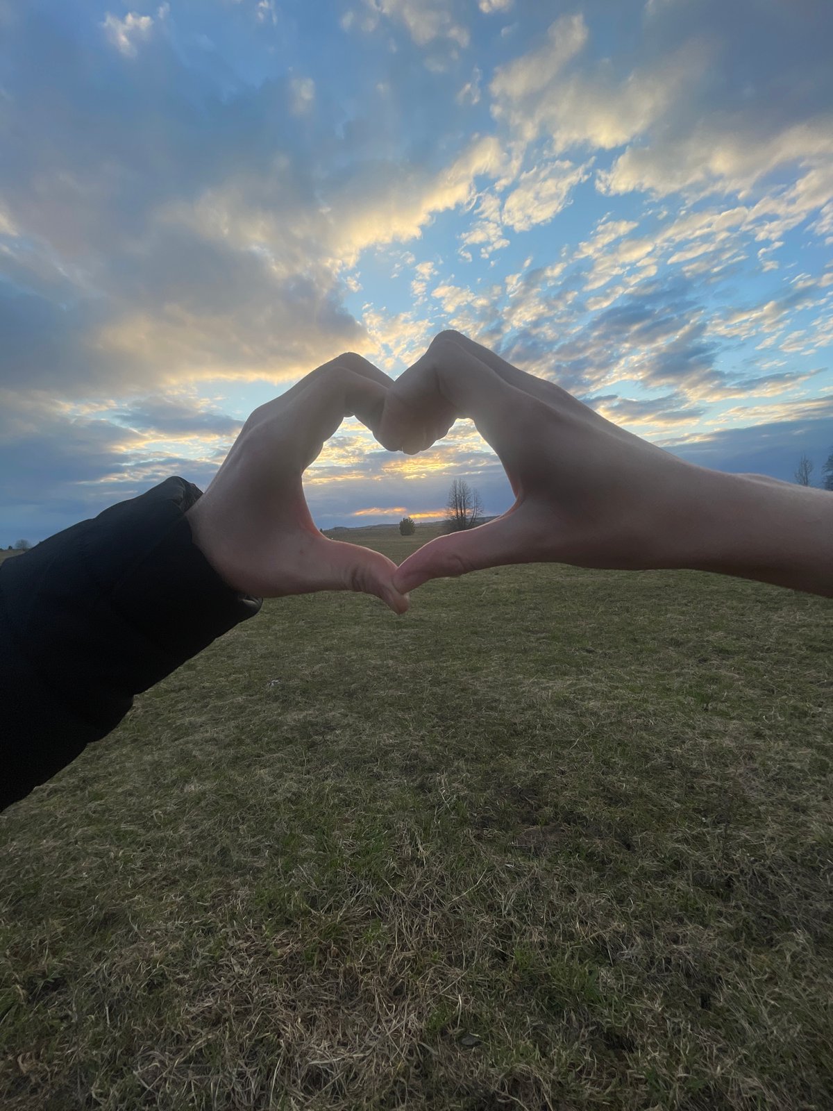 Heart gesture photographed against sky in Kuyeda, Russia