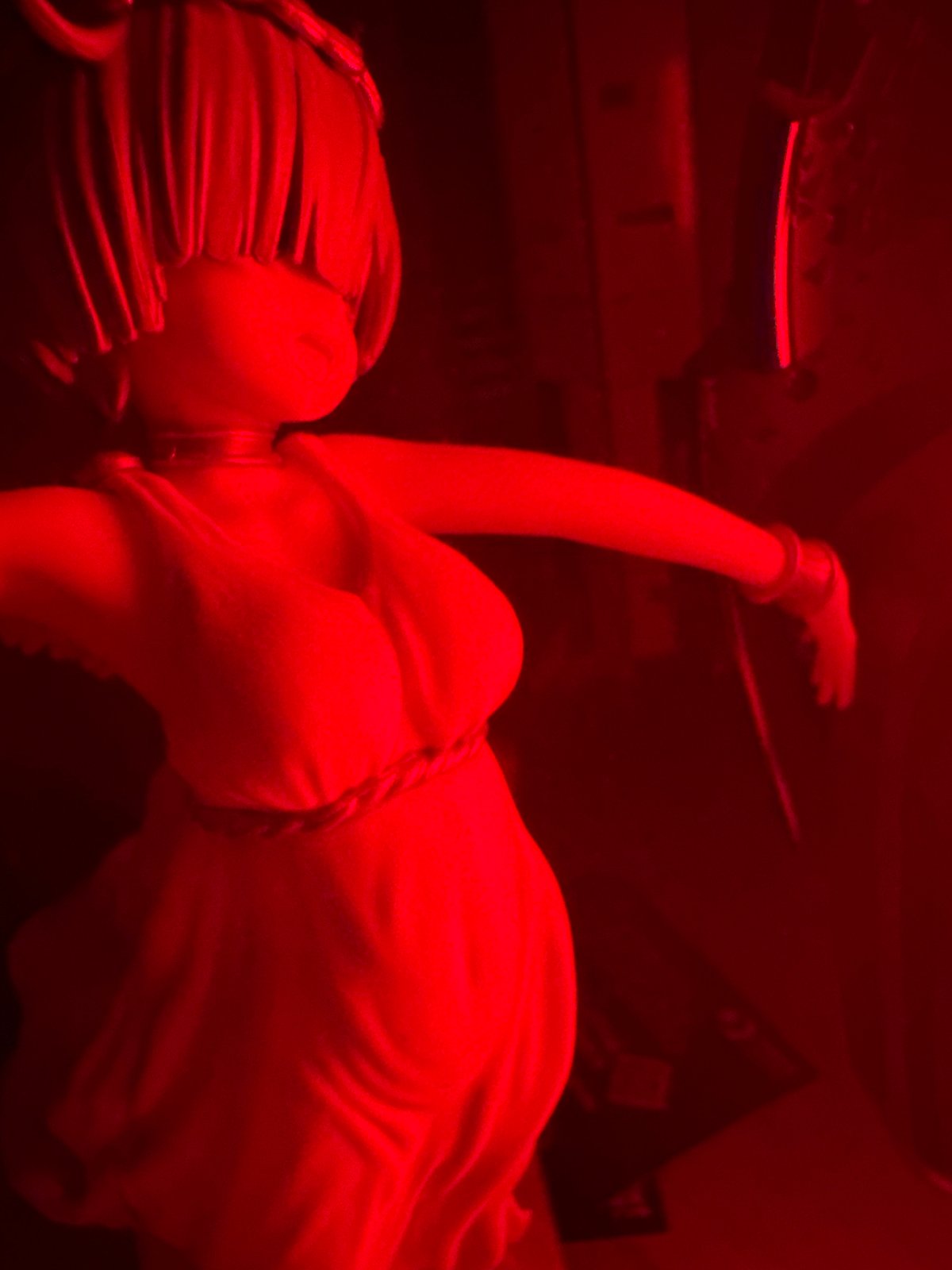 Red-lit anime figurine photography session with winged characters
