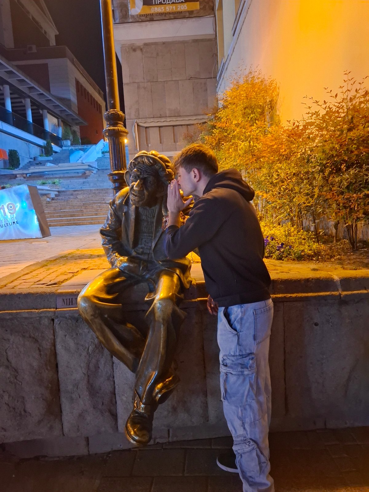 Man interacts with bronze statues in Plovdiv park