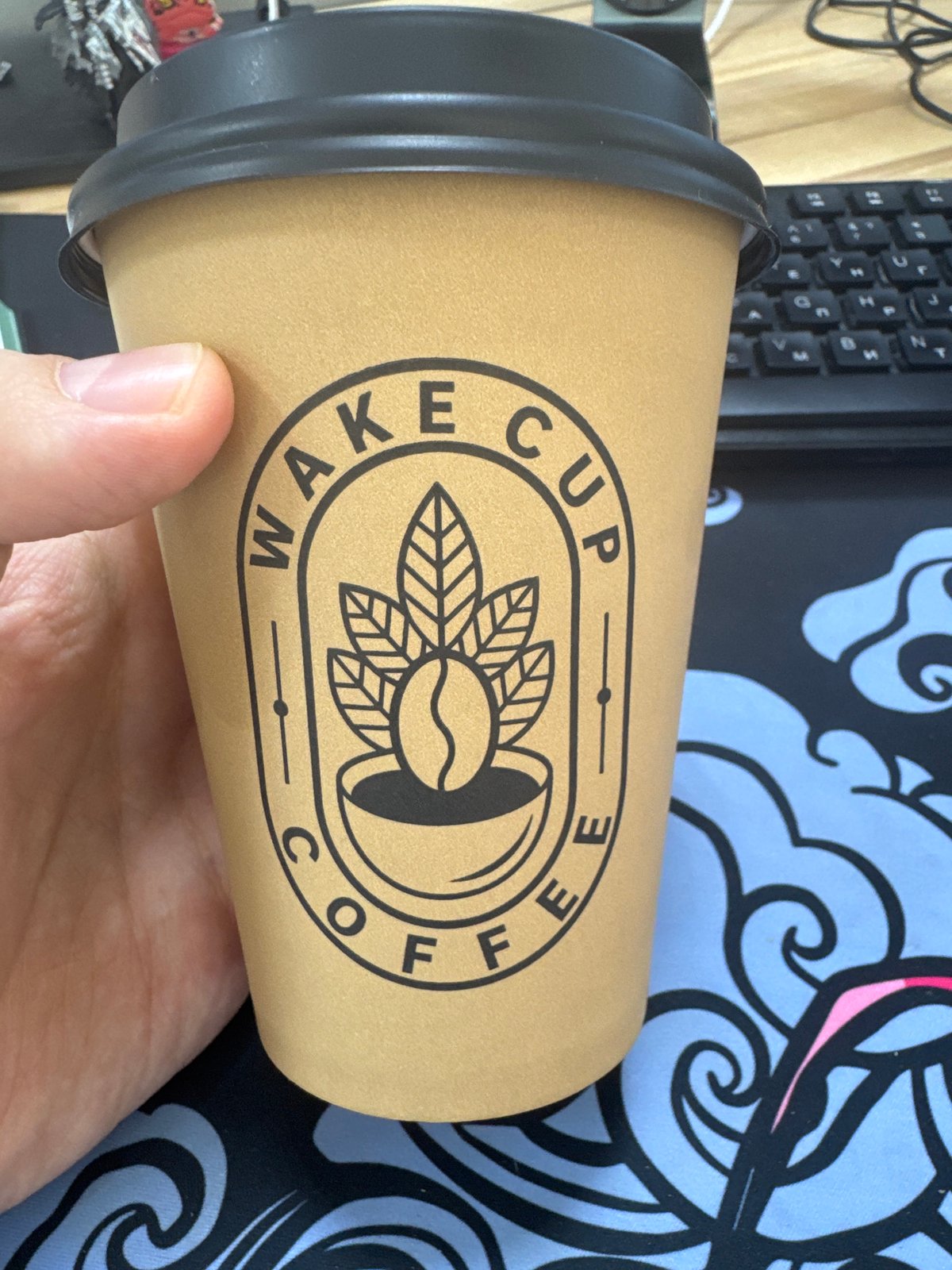 Person holds branded coffee cup at dawn
