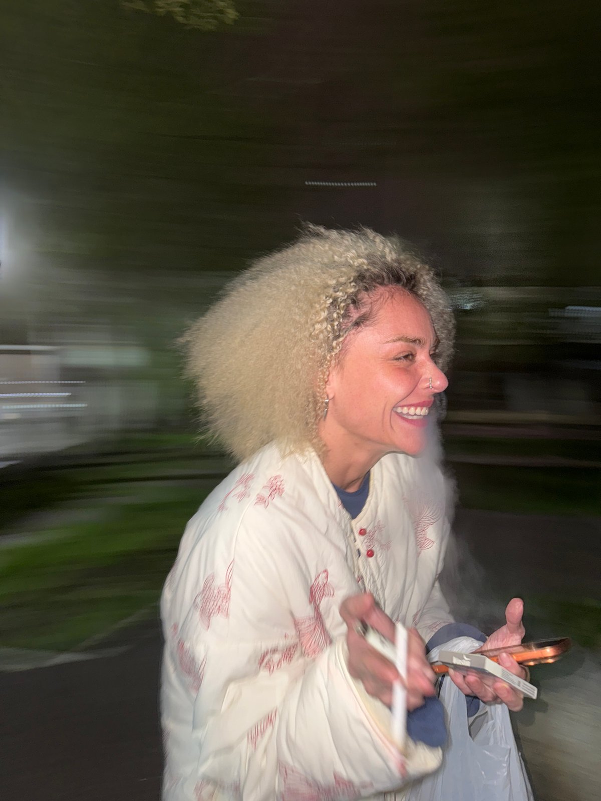 Blurred photo captures smiling woman with smartphone in Krasnoyarsk
