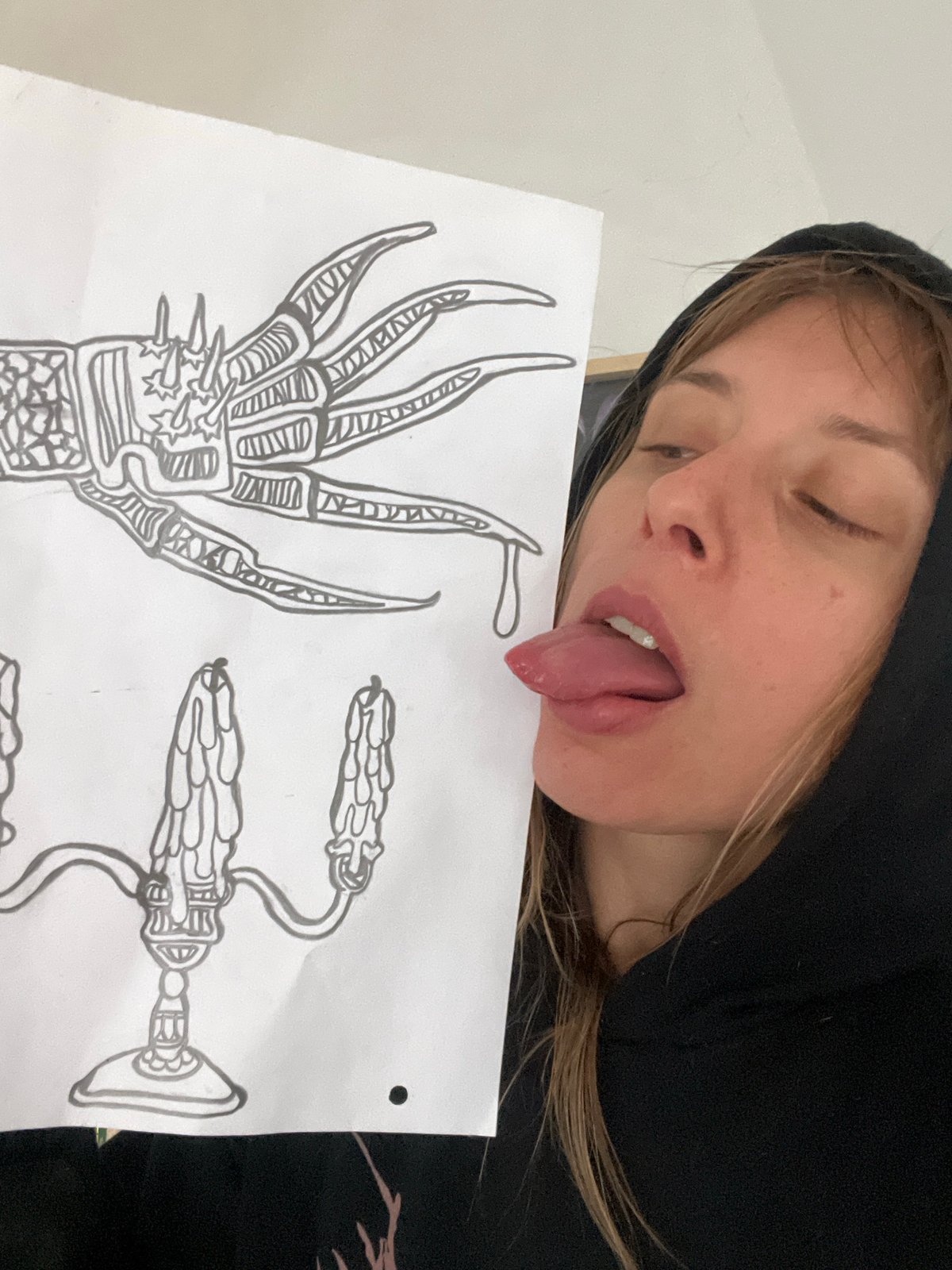 Person displays claw drawing while making playful expression in Buenos Aires