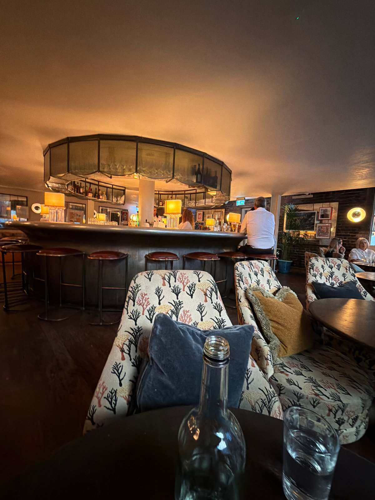 Quiet corner of a dim London bar, drinks on the table