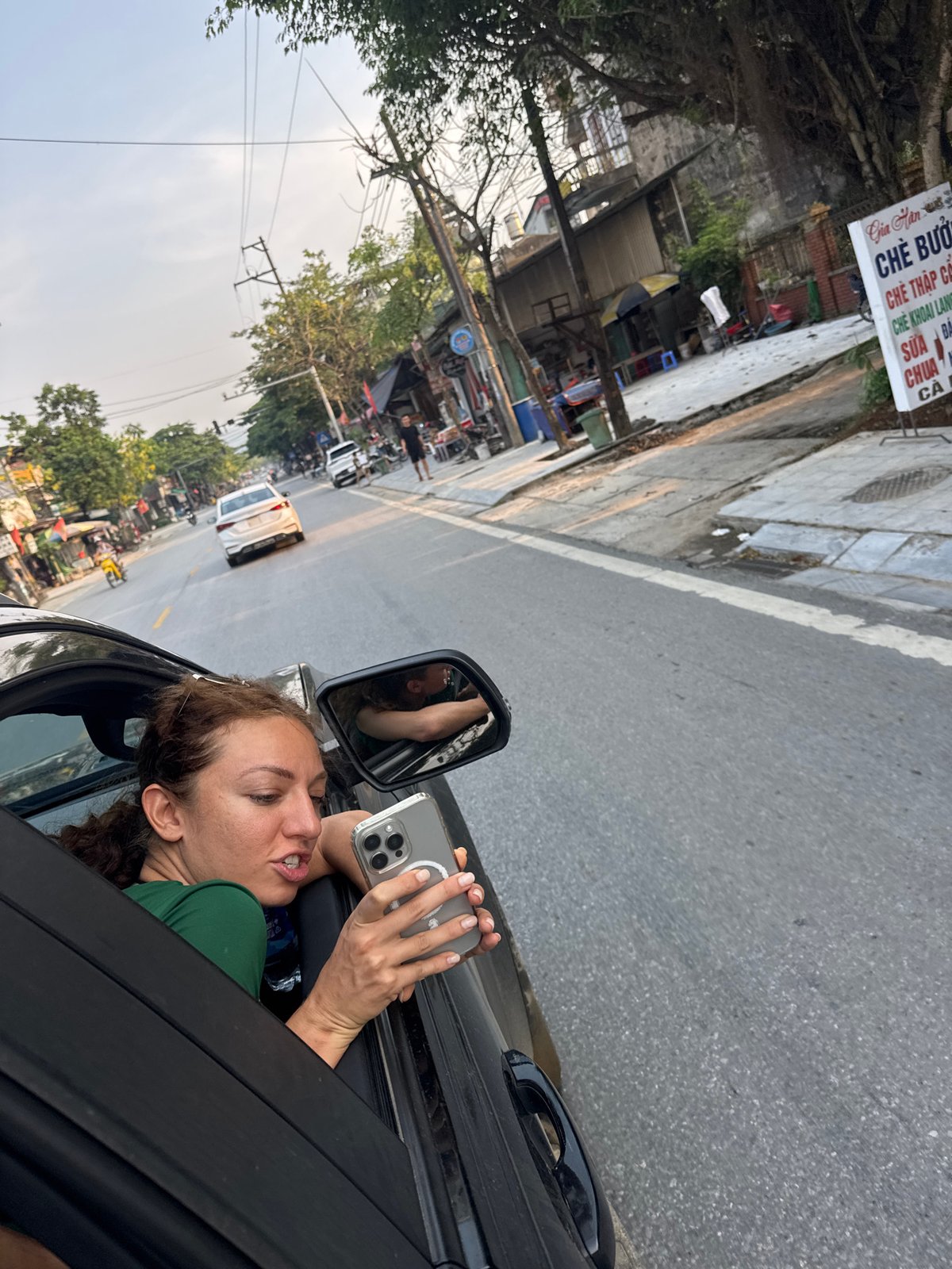 Woman films from car window on Vietnamese street