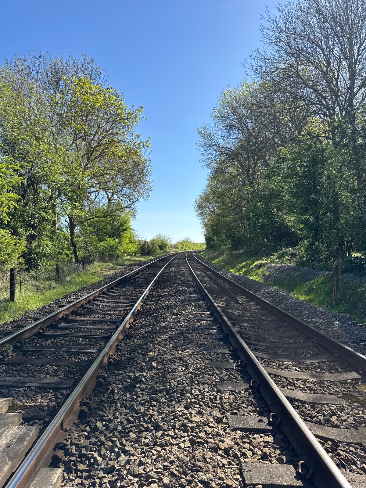Railway track through green countryside observed in Easton