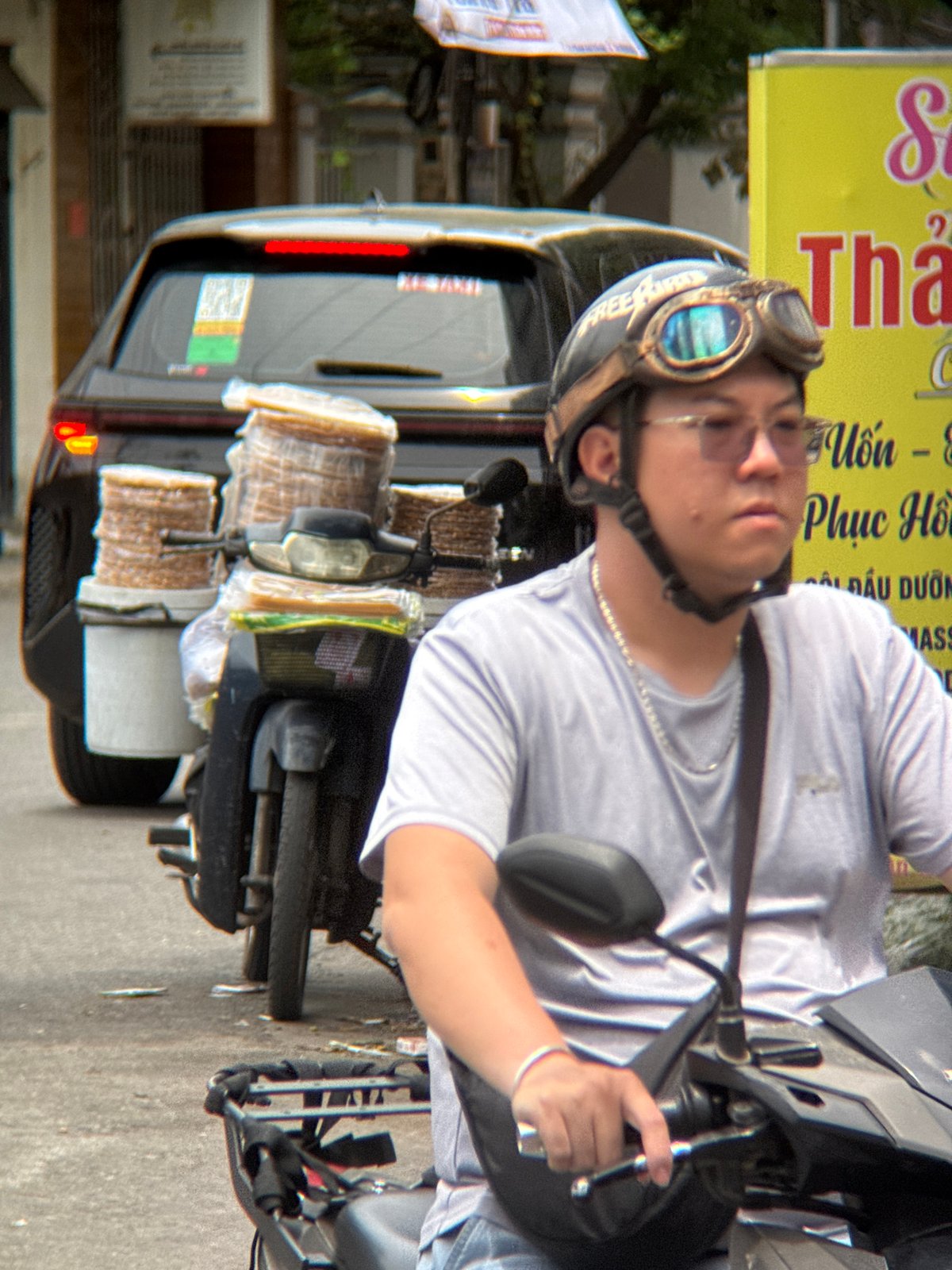 Nha Trang street traffic: scooters, passengers, and a pink-trimmed car