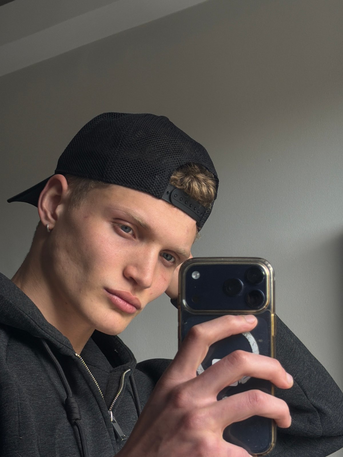 Young man takes selfies indoors in London residential setting