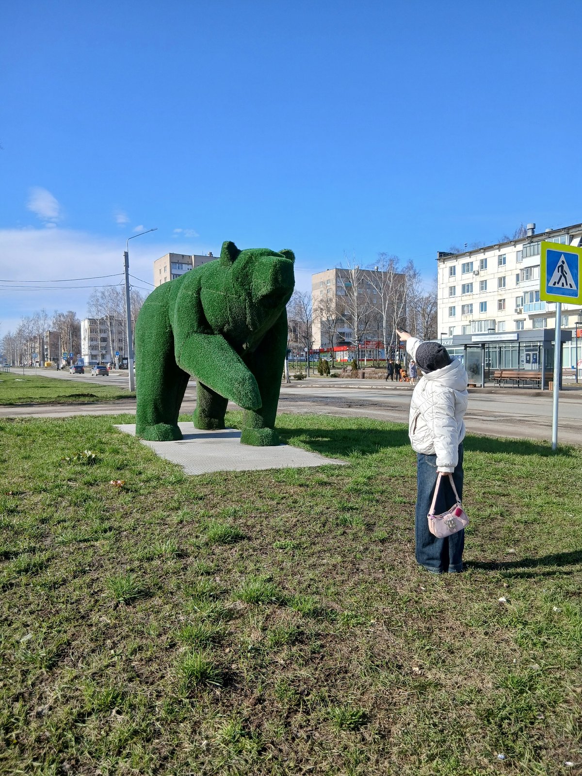Urban park visitors enjoy spring morning activities, topiary sculptures