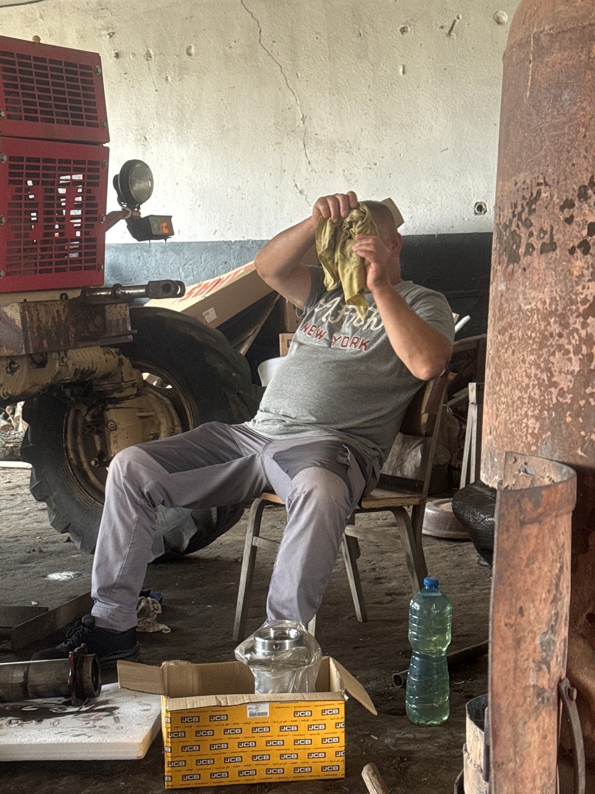 Early morning tractor repair session in Bulgarian village workshop