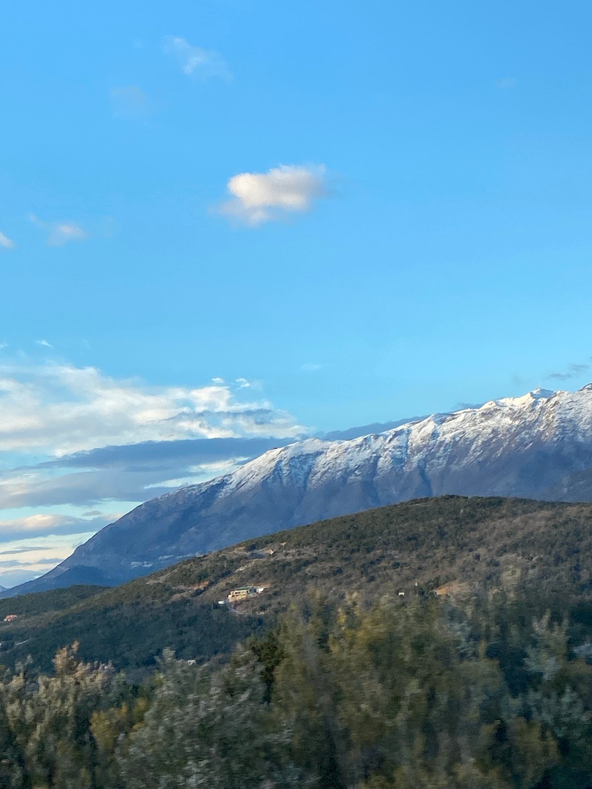 Snow-capped mountains viewed from vehicles in Montenegro countryside