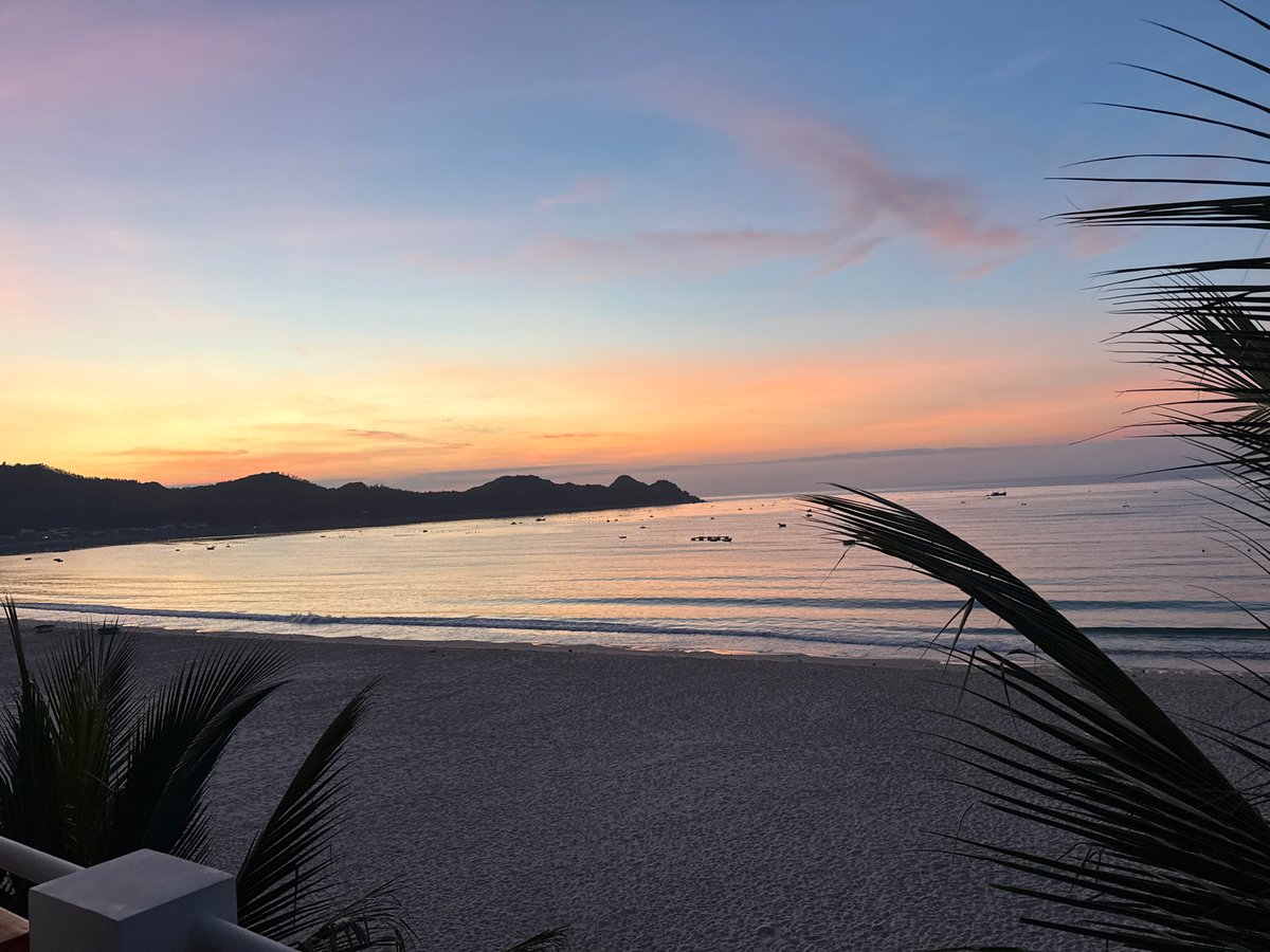 Golden hour at a coastal beach, mountains on the horizon