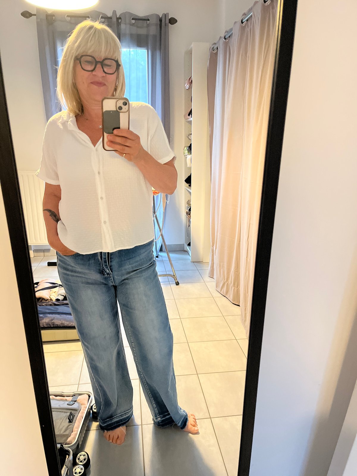 Woman takes morning mirror selfies in Chambœuf bedroom