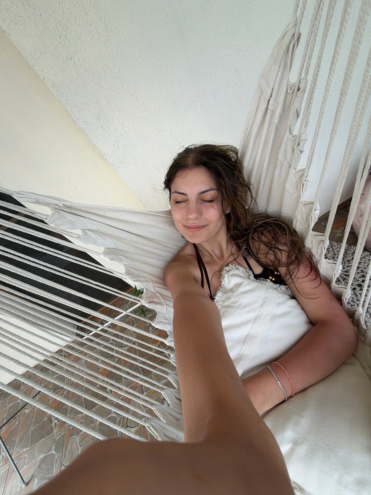 Woman relaxes in hammock on Bulgarian coastal balcony