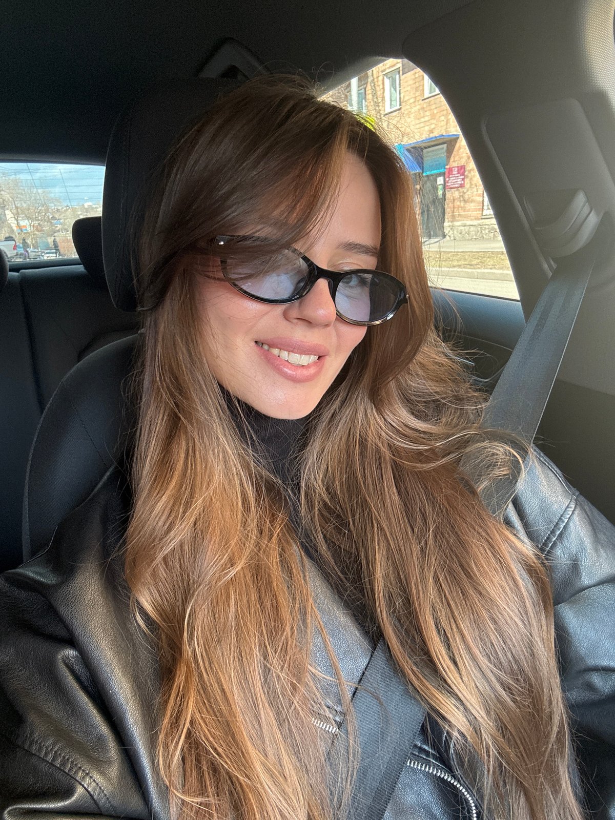 Person in leather jacket photographed in car, Krasnoyarsk