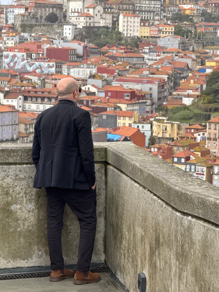 Man views Porto cityscape from Vila Nova de Gaia platform
