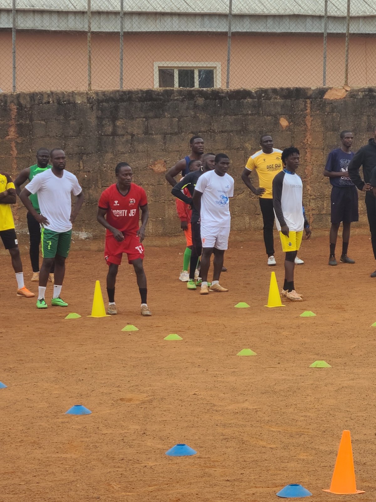Soccer training session observed on dirt field