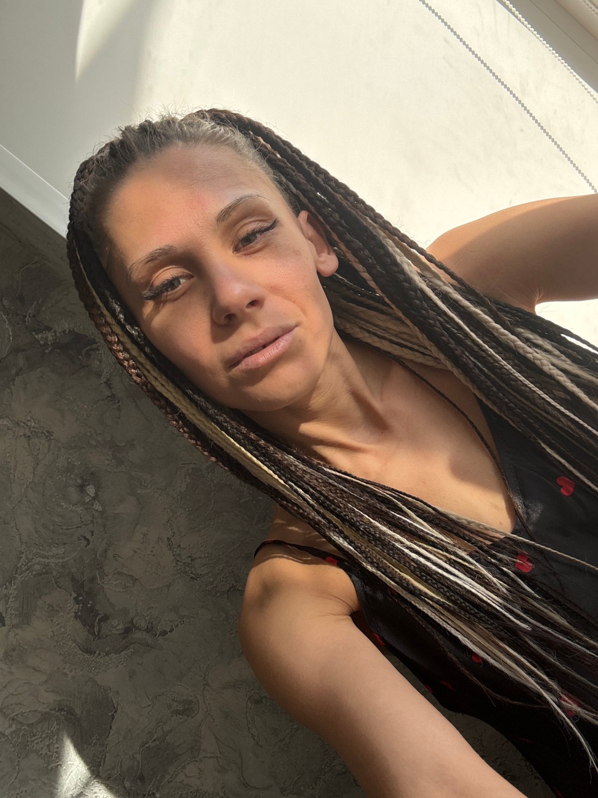 Woman with braided hair photographed indoors in dual poses
