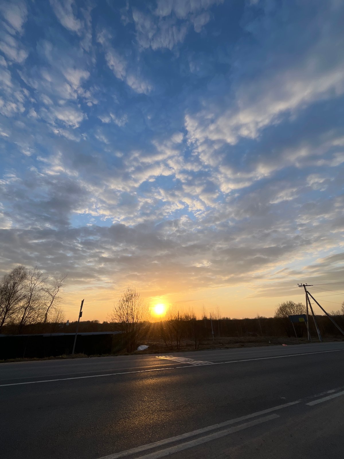 Woman captures sunset views during rural road journey in Russia