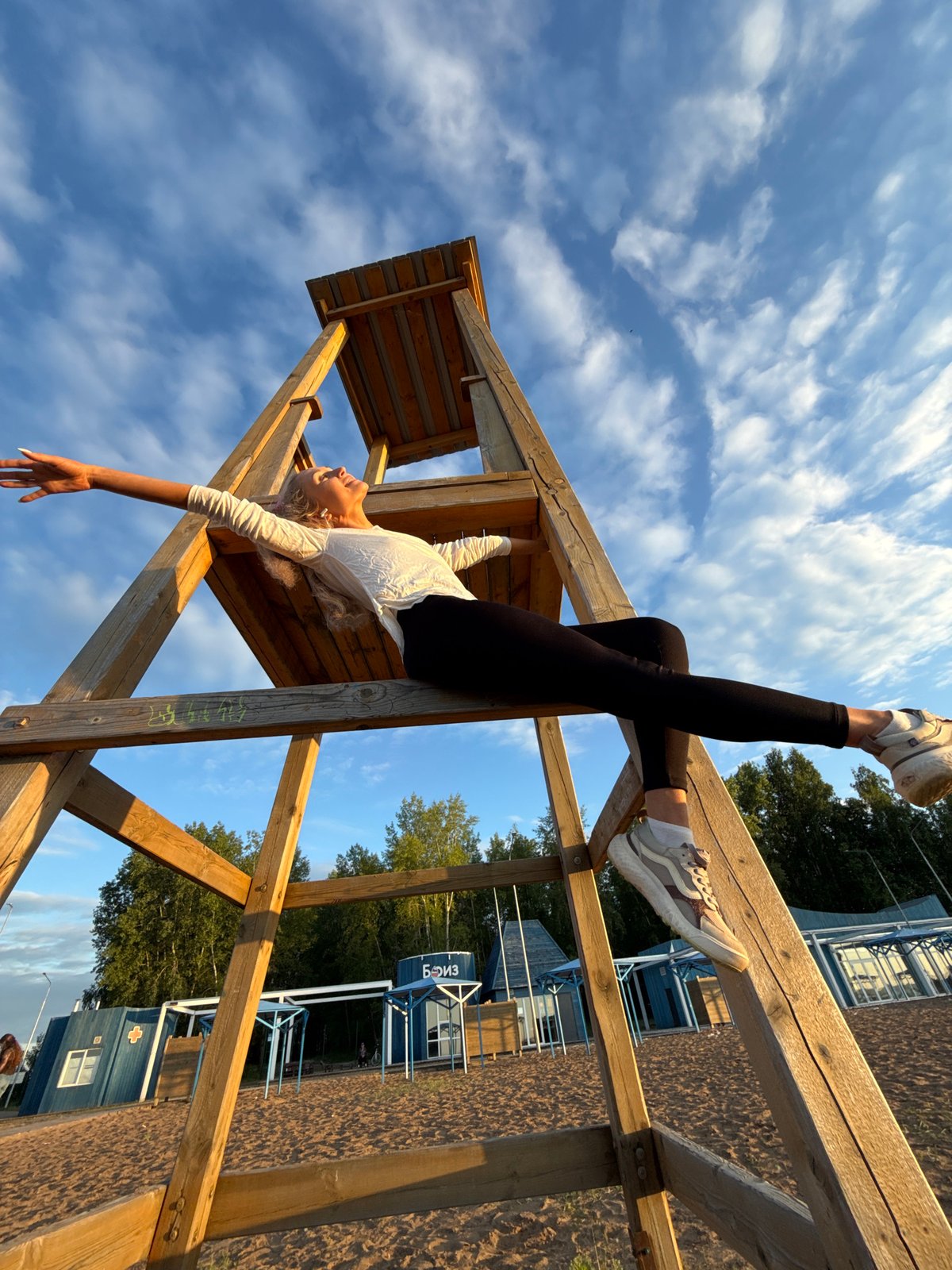 Woman photographed at sunset beach observation tower in Chaikovsky