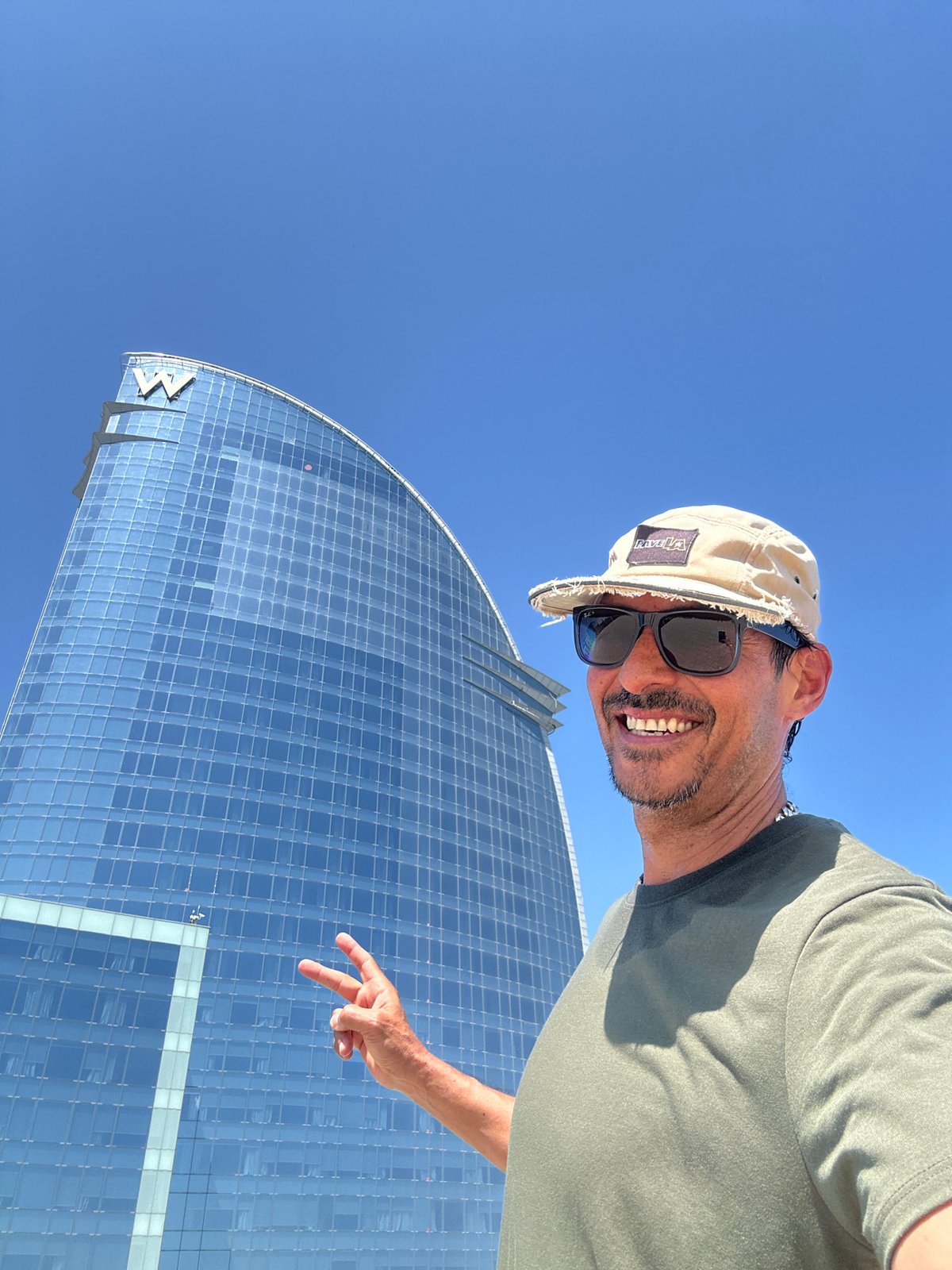 Tourist photographs himself at Barcelona's Barceloneta Beach near W Hotel