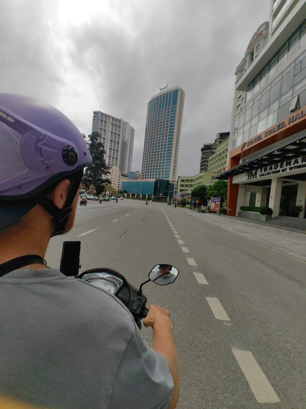 Morning scooter commute captured on urban road in Vietnam