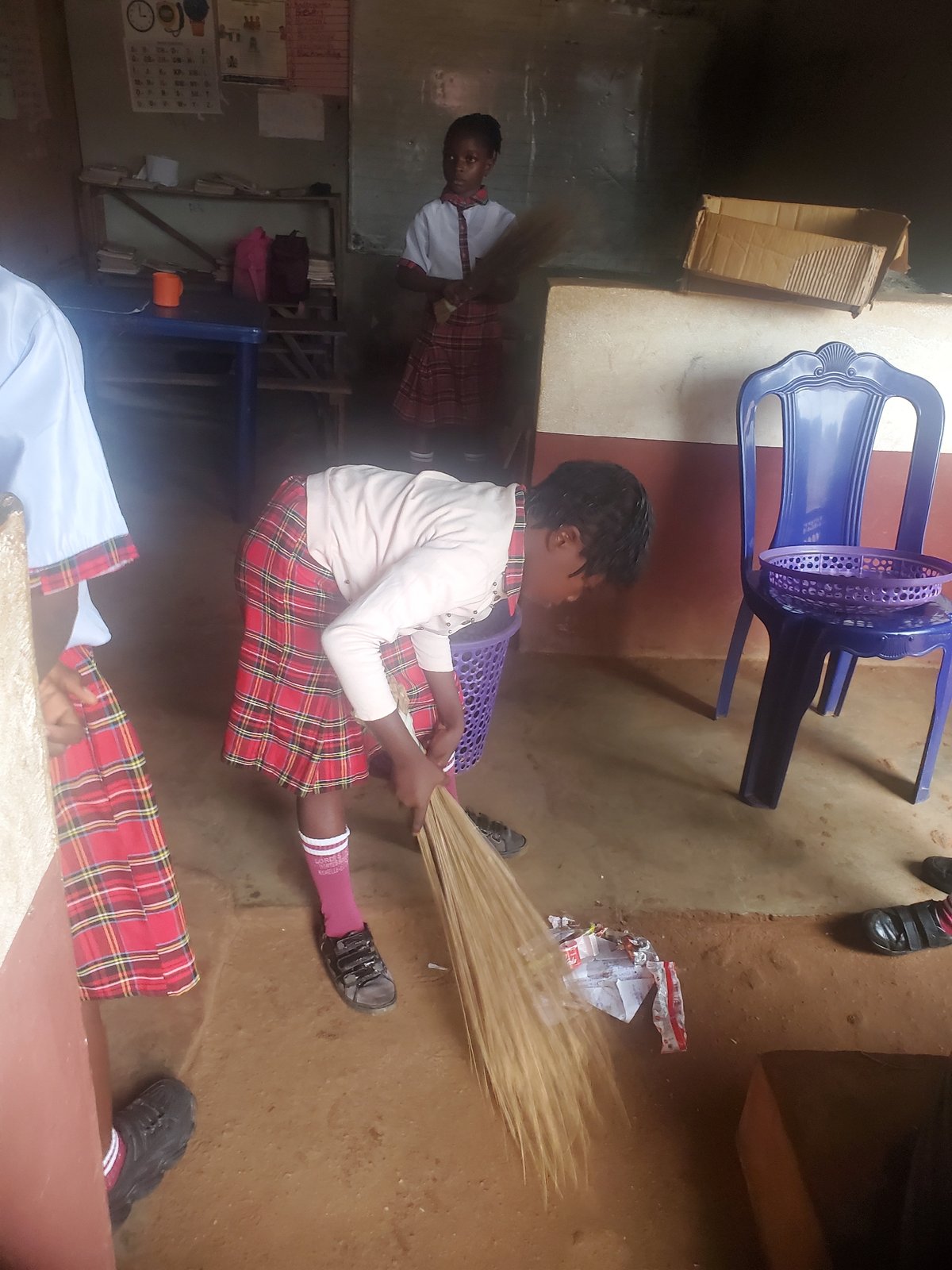 Young person sits with sticks in Ukwu-Abwa, Nigeria