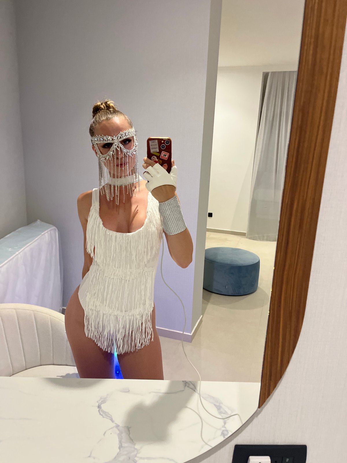Mirror selfie in rhinestone mask and light-up rainbow cape, Bar