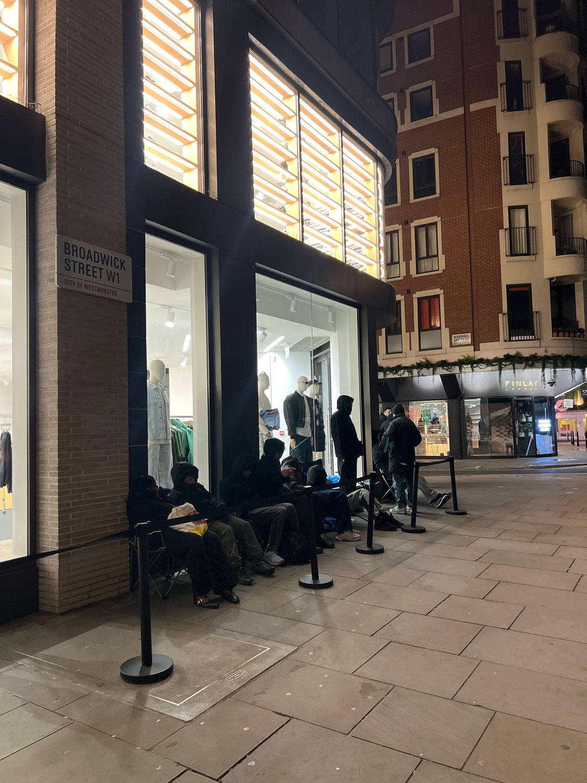 Nighttime queue forms outside London retail store